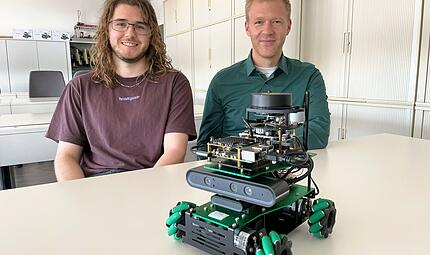 Das Unternehmen Siemens vermittelt KI-Kompetenz von Anfang an. Unter AuDas Unternehmen Siemens vermittelt KI-Kompetenz von Anfang an. Unter Aufsicht des Auszubildendenleiters Alexander Bach (r.) haben Azubis wie Micha Walter (l.) einen selbstfahrenden Roboter programmiert. Das Organisationstalent kann mittels KI einen digitalen Plan von einem Lager erstellen.fsicht des Auszubildendenleiters Alexander Bach (r.) haben Azubis wie Micha Walter (l.) einen Organisations-Roboter programmiert. Er kann mittels KI einen digitalen Plan von einem Lager erstellen.