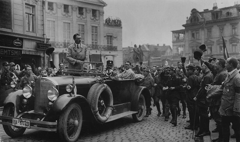 Adolf Hitler 1926 in Weimar Adolf Hitler wird bei seiner Ankunft in Weimar von SA-Männern begrüßt. Im Fond des Wagens Rudolf Heß – Aufnahme vom 03./04.07.1926