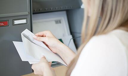 Eine Frau öffnet einen Brief Eine Frau öffnet einen Brief