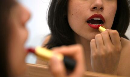 Lippenstift auftragen vor dem Spiegel Lippenstift auftragen vor dem Spiegel