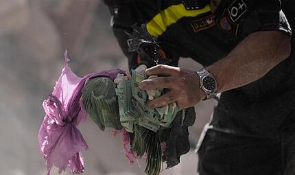 Ein Helfer hält Geldbündel aus den Trümmern eines zerstörten Gebäudes, das bei einem israelischen Luftangriff getroffen wurde. Die Krise im Nahen Osten wird sich bald auf die Finanzen Bayerns auswirken. Ein Helfer hält Geldbündel aus den Trümmern eines zerstörten Gebäudes, das bei einem israelischen Luftangriff getroffen wurde. Die Krise im Nahen Osten wird sich bald auf die Finanzen Bayerns auswirken.